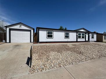 Charming home featuring a detached garage and rock landscaping for easy maintenance at 8362 Jasmine St, Commerce City, CO 80022