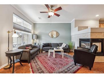 Inviting living room featuring a fireplace, ceiling fan, stylish rug, and ample natural light at 10007 Martin Luther King Blvd # 104, Denver, CO 80238