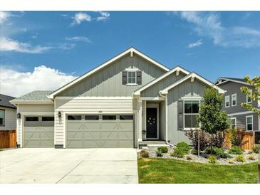 Charming exterior featuring a two-car garage, landscaped yard, and a welcoming front porch at 1171 Nathan Pl, Erie, CO 80026