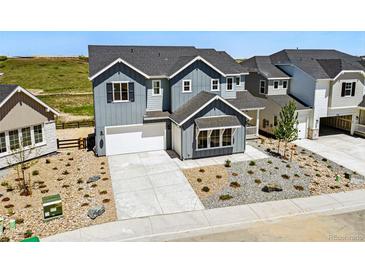 Charming two-story home featuring gray siding, a well-manicured yard, and a spacious driveway and attached garage at 3327 Backdrop Ct, Castle Rock, CO 80108