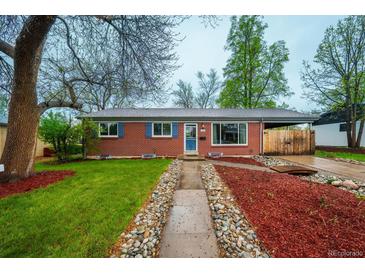 Charming red brick home with well-manicured lawn, blue shutters, and a welcoming walkway at 3200 W Chenango Ave, Englewood, CO 80110