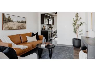 Bright living room with leather couch and view of kitchen at 1448 W Nevada Pl, Denver, CO 80223