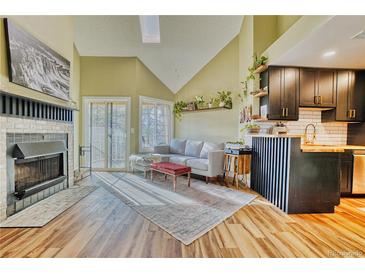 Bright living room features vaulted ceilings, a fireplace, access to the balcony and an open connection to the kitchen at 4771 White Rock Cir # C, Boulder, CO 80301