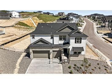 Stunning two-story home boasting a three car garage, manicured landscaping, and modern architectural details at 1733 Fox Trotter Pt, Castle Rock, CO 80104