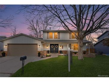 Charming two-story home featuring a well-manicured lawn, double front doors, and attached two-car garage at 3930 S Spruce St, Denver, CO 80237