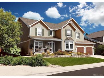 Two-story house with landscaped yard, attached garage, and inviting front porch at 2834 S Fig St, Lakewood, CO 80228