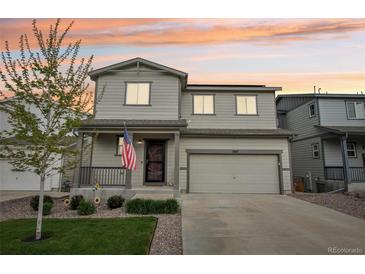 Charming two-story home featuring a covered porch, two-car garage, and well-maintained front yard with mature tree at 1607 Goldfield Trl, Castle Rock, CO 80109