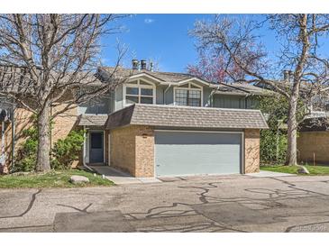 Charming townhome featuring a brick facade and attached garage, with mature trees surrounding the property at 3850 Paseo Del Prado # 29, Boulder, CO 80301
