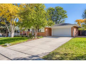 Charming brick home featuring a well-manicured front yard, a long driveway, and an attached two-car garage at 6642 S Pearl St, Centennial, CO 80121