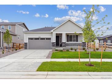Charming single-story home with well-manicured lawn, gray siding, and a covered front porch at 24740 E 39Th Ave, Aurora, CO 80019