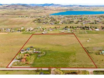Expansive land outlined in red, showing property lines of land with rolling hills and a distant lake at 6310 W County Road 4, Berthoud, CO 80513