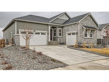 Charming home featuring stone accents, a two-car garage, and a well-maintained front yard landscape design at 3630 Gold Bug St, Aurora, CO 80019