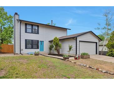 Charming two-story home featuring a well-manicured lawn and a bright blue front door at 3575 S Ouray St, Aurora, CO 80013