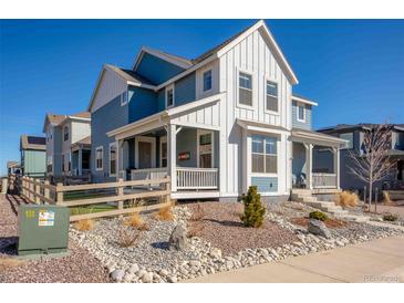 Charming two-story home with white siding and a covered porch, complemented by rocky landscaping at 8409 Rush Creek Ave, Littleton, CO 80125