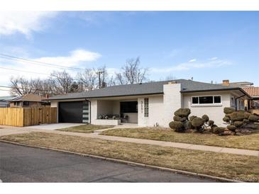 Charming single-story home featuring a modern garage door, manicured front yard, and brick facade at 3501 W 41St Ave, Denver, CO 80211