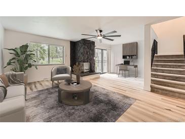 Light-filled living room featuring a unique fireplace, modern ceiling fan, and neutral decor at 12010 E Harvard Ave, Aurora, CO 80014