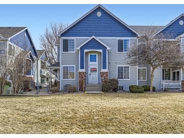 Charming townhome featuring a blue and gray exterior and a well-maintained front yard at 12941 Lafayette St # E, Thornton, CO 80241