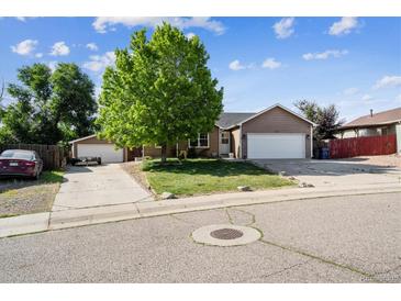 Charming single-Gathering home with lush green lawn, mature tree, and long driveway at 1115 Cherry Ct, Fort Lupton, CO 80621