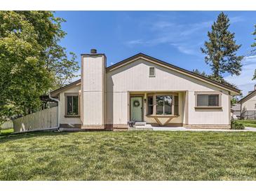 Charming single-story home with cream siding, a chimney, and a well-maintained lawn at 7830 W 90Th Ave # 67, Broomfield, CO 80021