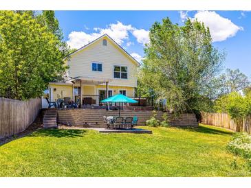 Well-maintained lawn featuring a table with umbrella and chair seating for relaxing in the backyard at 3962 Hoyt Ct, Wheat Ridge, CO 80033