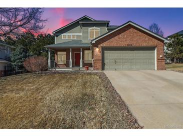 Inviting two-story home with a brick facade, attached garage and covered front porch at 10795 Quail Creek E Dr, Parker, CO 80138