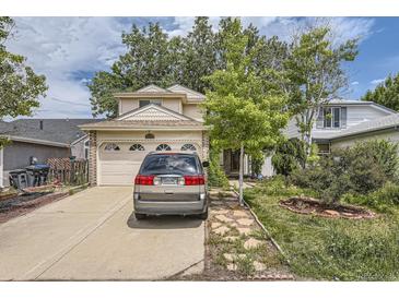 Two-story home featuring an attached two-car garage, a long driveway, mature shade trees and manicured landscaping at 2370 Redwood Ave, Lafayette, CO 80026