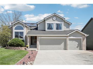 Charming two-story home with a three-car garage, inviting curb appeal, and mature landscaping at 11035 W Grand Pl, Littleton, CO 80127