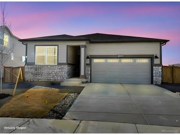 Charming single-story home featuring stone accents and a two-car garage at 8945 Rifle St, Commerce City, CO 80022