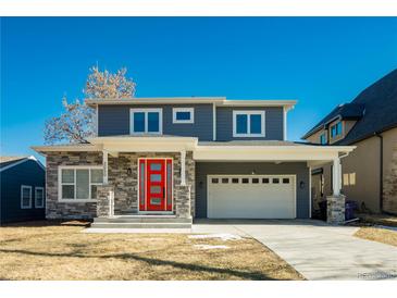 Two-story craftsman style home with gray siding, stone accents and a red door at 3050 S Ash St, Denver, CO 80222