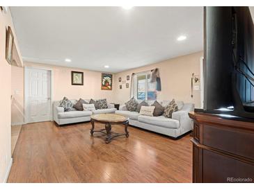 Inviting living room with hardwood floors and comfortable seating, perfect for relaxing and entertaining guests at 7511 Locust St, Commerce City, CO 80022