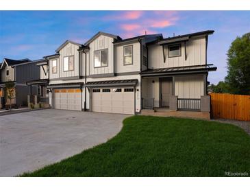 Modern townhome boasts neutral paint, two-car garage and grassy front lawn at 4030 Upham St, Wheat Ridge, CO 80033