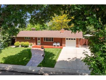 Charming red brick home with a manicured lawn, front porch, and a spacious driveway at 1040 Zang St, Golden, CO 80401