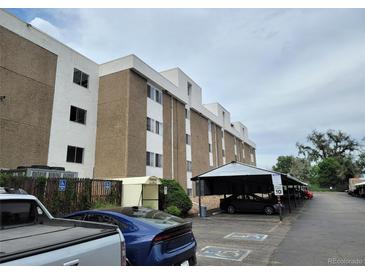 Apartment complex exterior featuring covered parking and handicap parking spaces on a cloudy day at 384 S Ironton St # 407, Aurora, CO 80012