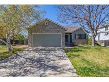 Charming home features a well-manicured lawn and a two-car garage, providing convenience and curb appeal at 5335 S Lisbon Way, Centennial, CO 80015