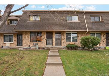 Charming townhouse with brick facade, well-maintained lawn, and inviting entryway creates a warm welcome at 11228 W 18Th Ave, Lakewood, CO 80215