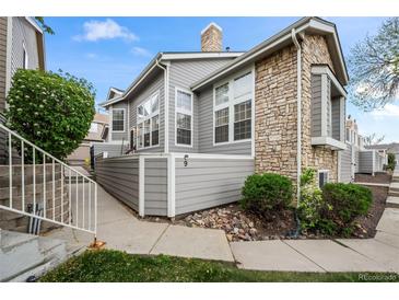 Inviting condo exterior boasts stone accents, gray siding, and well-maintained landscaping at 6848 Zenobia St # 9, Westminster, CO 80030