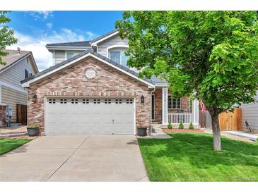 Charming two-story home featuring a brick facade, a two-car garage, and a well-manicured front yard at 7472 S Memphis St, Aurora, CO 80016