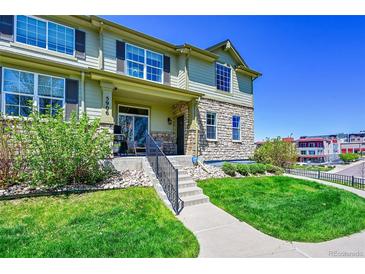 Inviting two-story home boasts stone accents, a well-maintained lawn, and a charming front porch at 5906 S Youngfield Way, Littleton, CO 80127