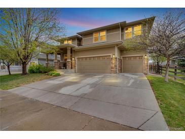 Charming two-story home featuring a three-car garage and covered front porch at 1033 Petras St, Erie, CO 80516