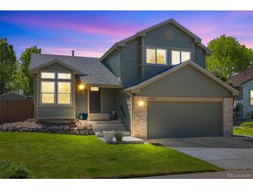 Charming two-story home with a well-manicured lawn, an attached garage, and inviting curb appeal at 9494 Devonshire Pl, Highlands Ranch, CO 80126
