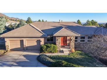Charming ranch style home featuring a stone facade and a two-car garage nestled on a verdant lot at 6260 Rain Dance Trl, Littleton, CO 80125