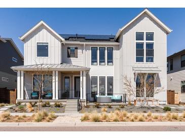 Stunning two-story home with solar panels, inviting porch, and beautifully landscaped front yard at 5835 Chester Way, Denver, CO 80238