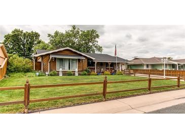 Charming home with a well-manicured lawn and inviting wood fence at 840 Essex Dr, Denver, CO 80229