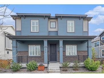 Charming two-story home with a welcoming front porch and beautifully landscaped front yard at 10610 Reunion Pkwy, Commerce City, CO 80022
