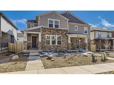 Charming two-story home featuring a stone facade, covered porch, and well-maintained landscaping in a vibrant community at 745 N Tempe St, Aurora, CO 80018