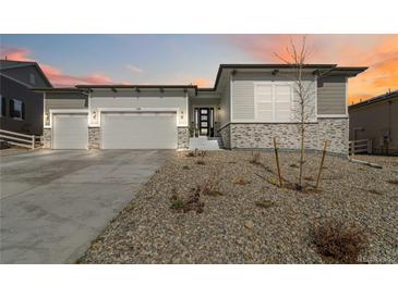 Charming single Gathering home featuring a stone facade, two-car garage, and minimalistic front yard at 1581 Diamond Hill Ct, Castle Rock, CO 80104