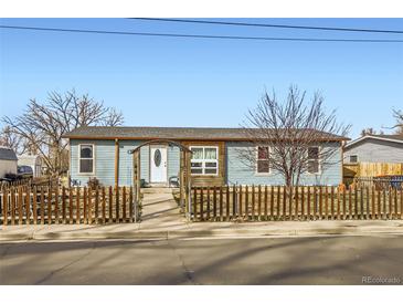 Charming exterior view of a light blue home with a picket fence and arched entrance at 441 Johnson St, Frederick, CO 80530