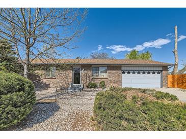 Charming brick home featuring a well-maintained yard with mature landscaping and a two-car garage at 125 S Fulton Ave, Fort Lupton, CO 80621