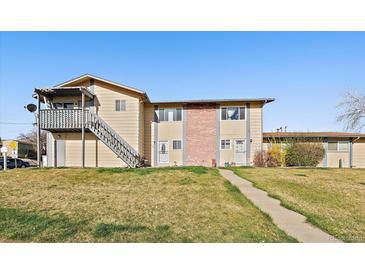 Inviting townhome featuring a well-maintained lawn, neutral color scheme, and a stairway entry to the second level at 1028 Coronado Pkwy # C, Denver, CO 80229