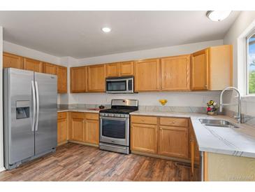 Well-lit kitchen features stainless steel appliances, light wood cabinets and marbled countertops at 1842 Reliance Cir, Superior, CO 80027